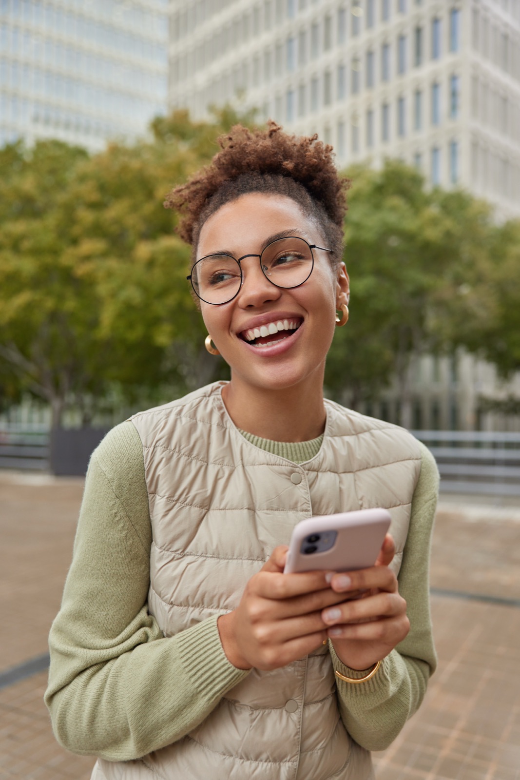 Creator sorrindo enquanto navega no celular comparando opções de plataforma para criar conteúdo.