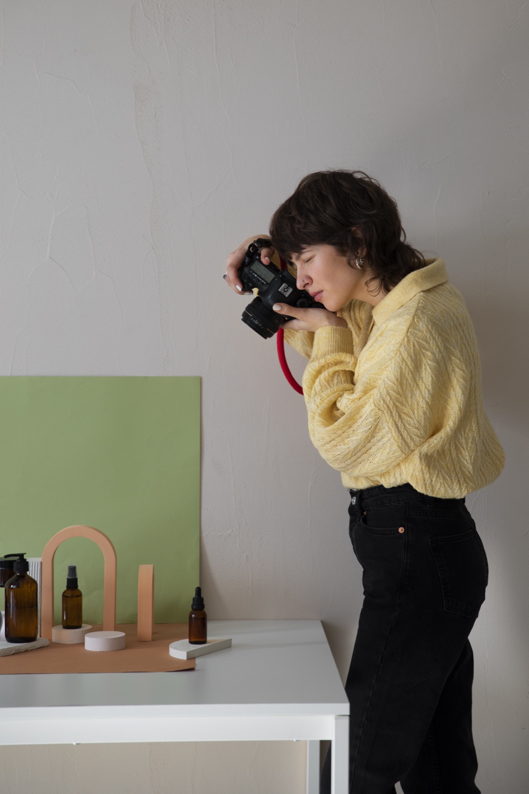Creator fotografando produtos de skincare em um mini estúdio para montar o portfólio de UGC.
