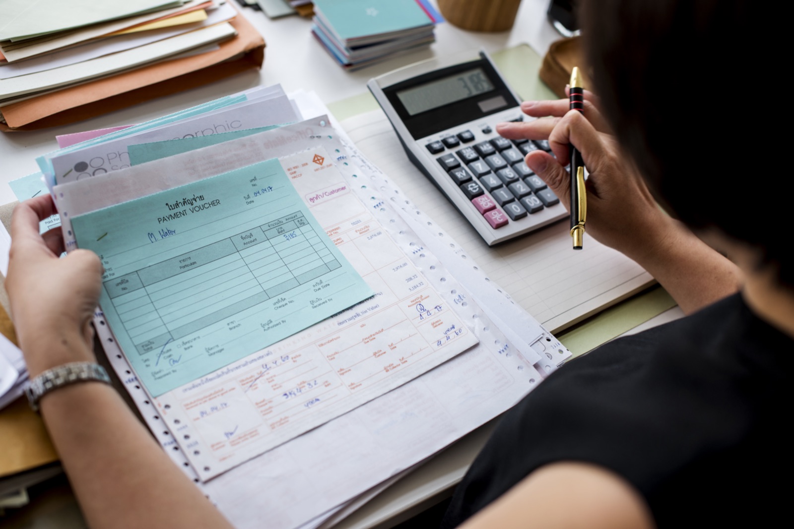 Creator organizando notas e valores com calculadora para definir quanto cobrar por um trabalho de UGC.
