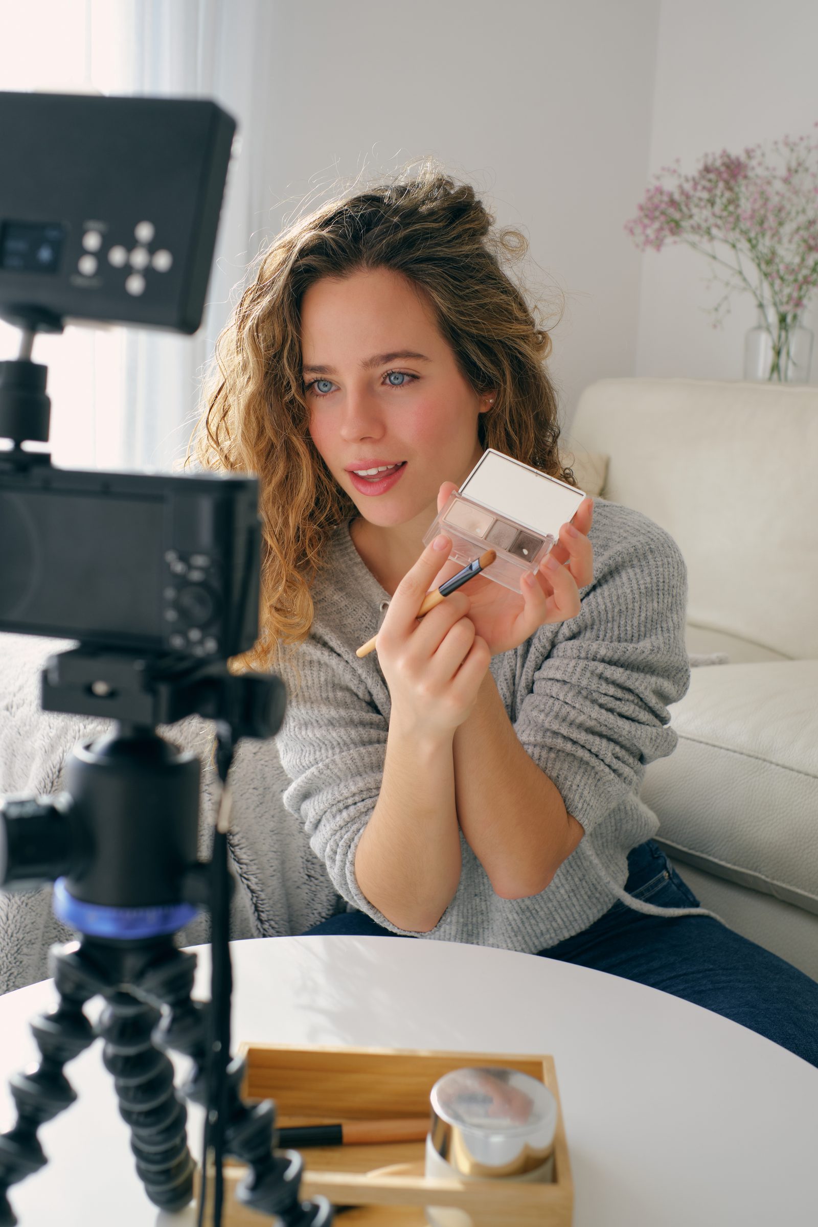 Creator gravando um review de cosméticos com a câmera na mesa.