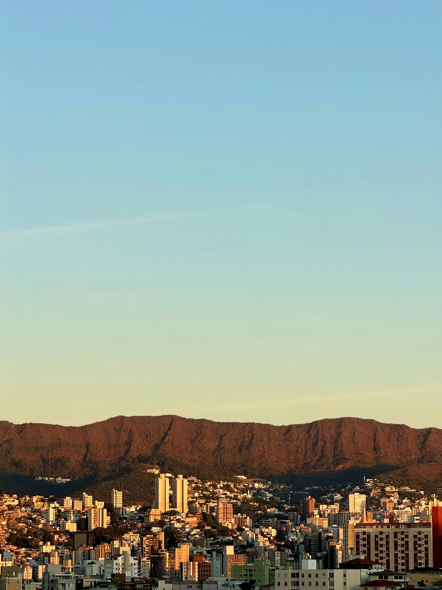 Vista da cidade de Belo Horizonte ao entardecer com a Serra do Curral ao fundo.