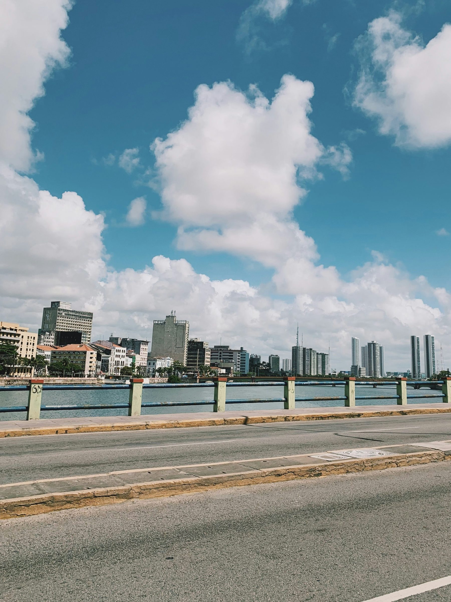 Ponte sobre o rio com o skyline de Recife ao fundo.