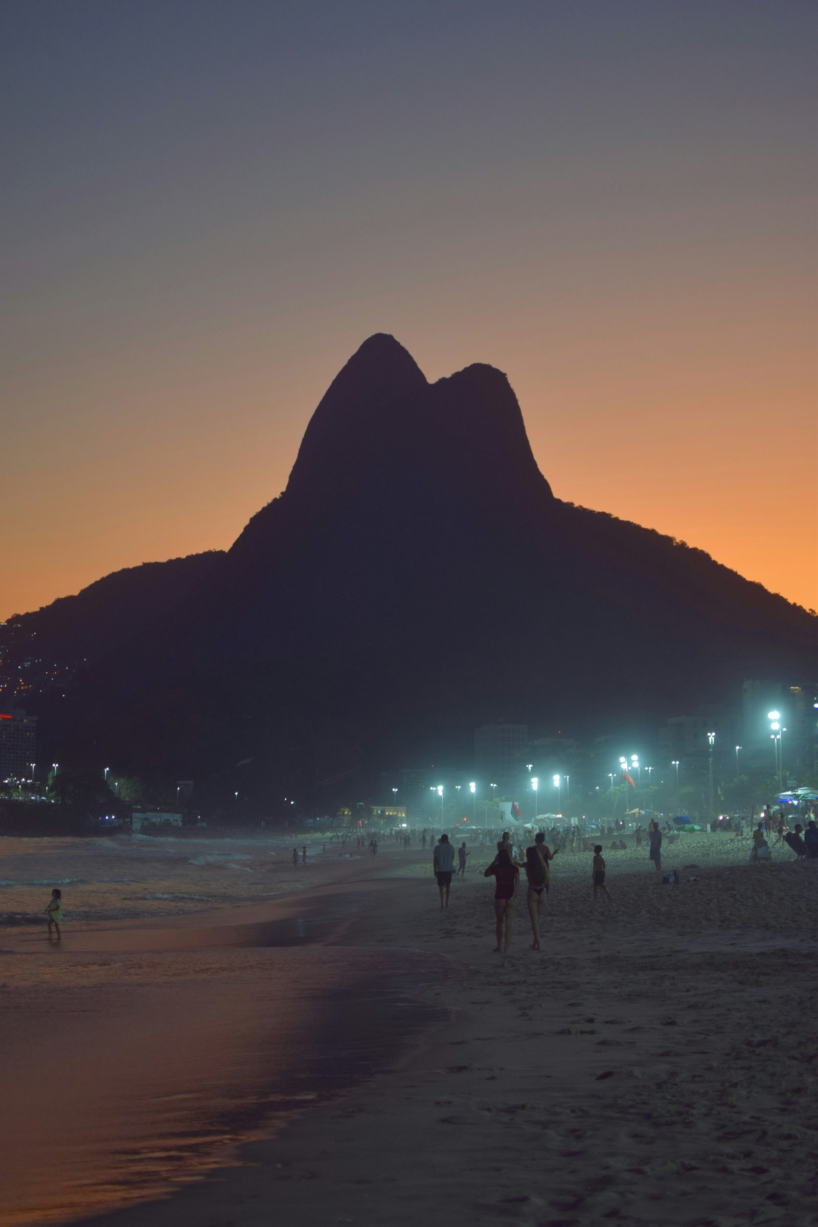 Praia de Ipanema com o Morro Dois Irmãos ao fundo ao entardecer.