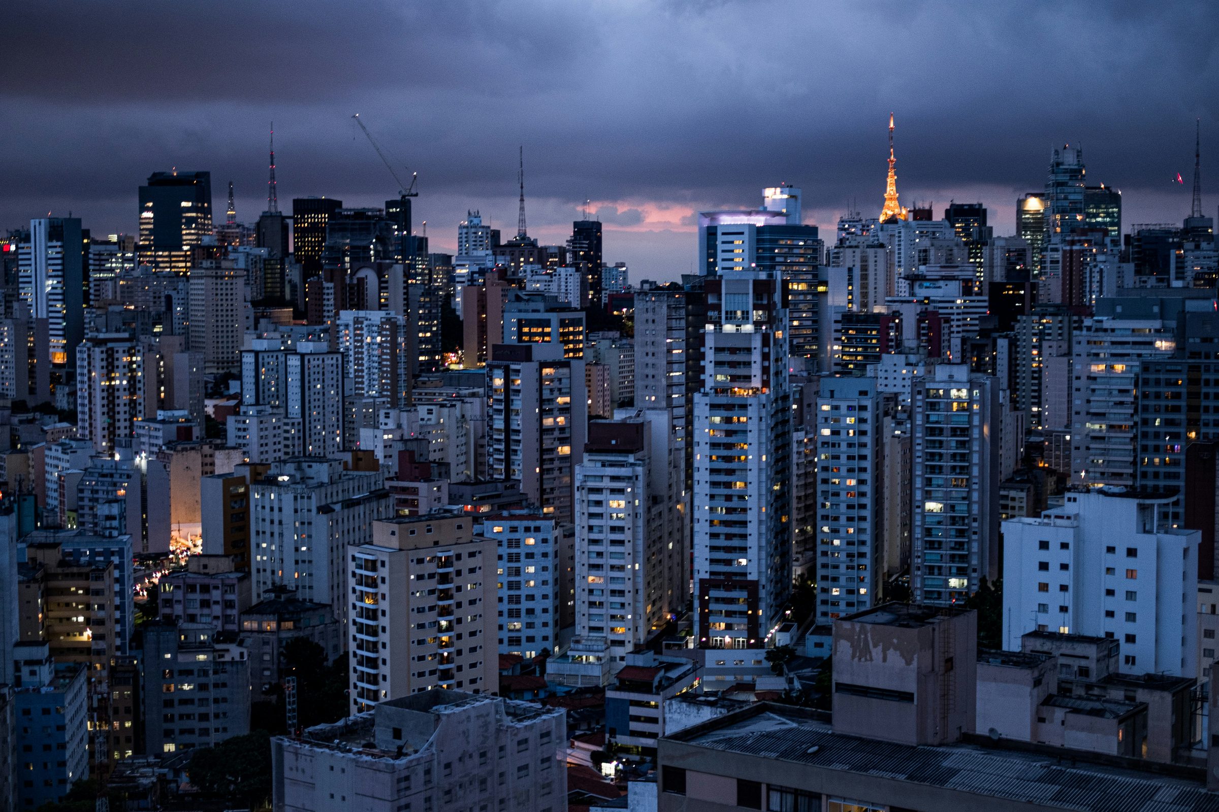 Skyline de prédios de São Paulo ao anoitecer com o Edifício Itália ao fundo.