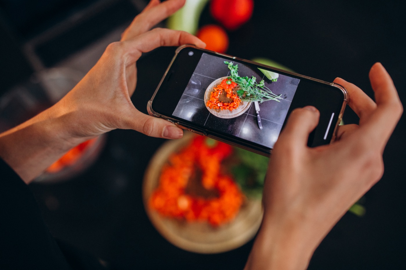 Creator fotografando um prato de comida com o celular para publicar nas redes.