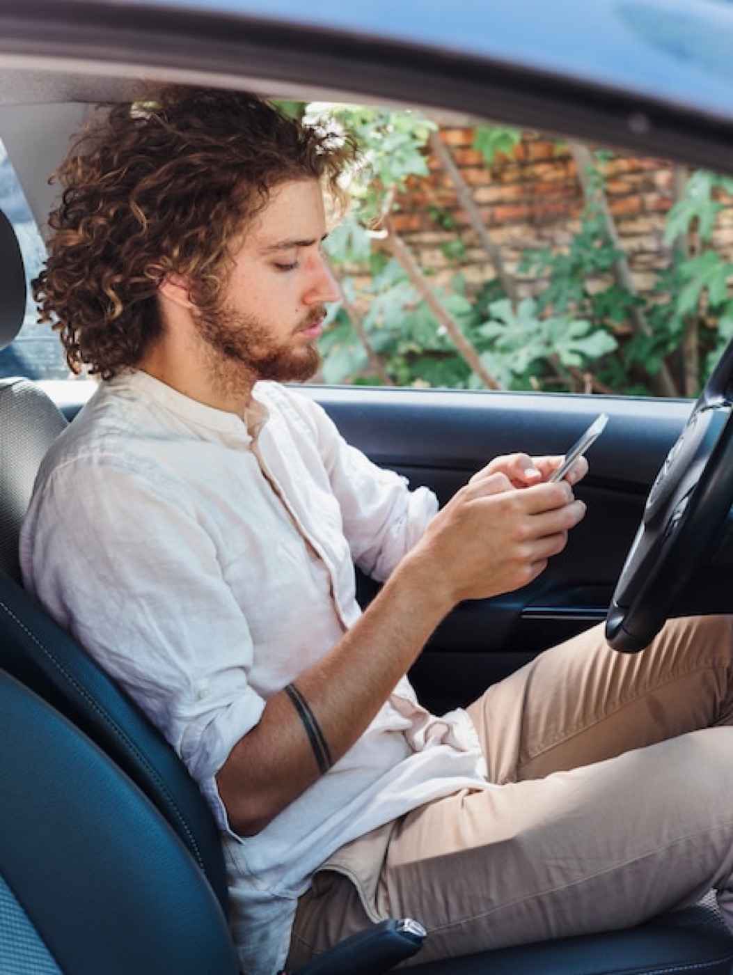 Creator automotivo gravando conteúdo sobre um carro usando o smartphone.