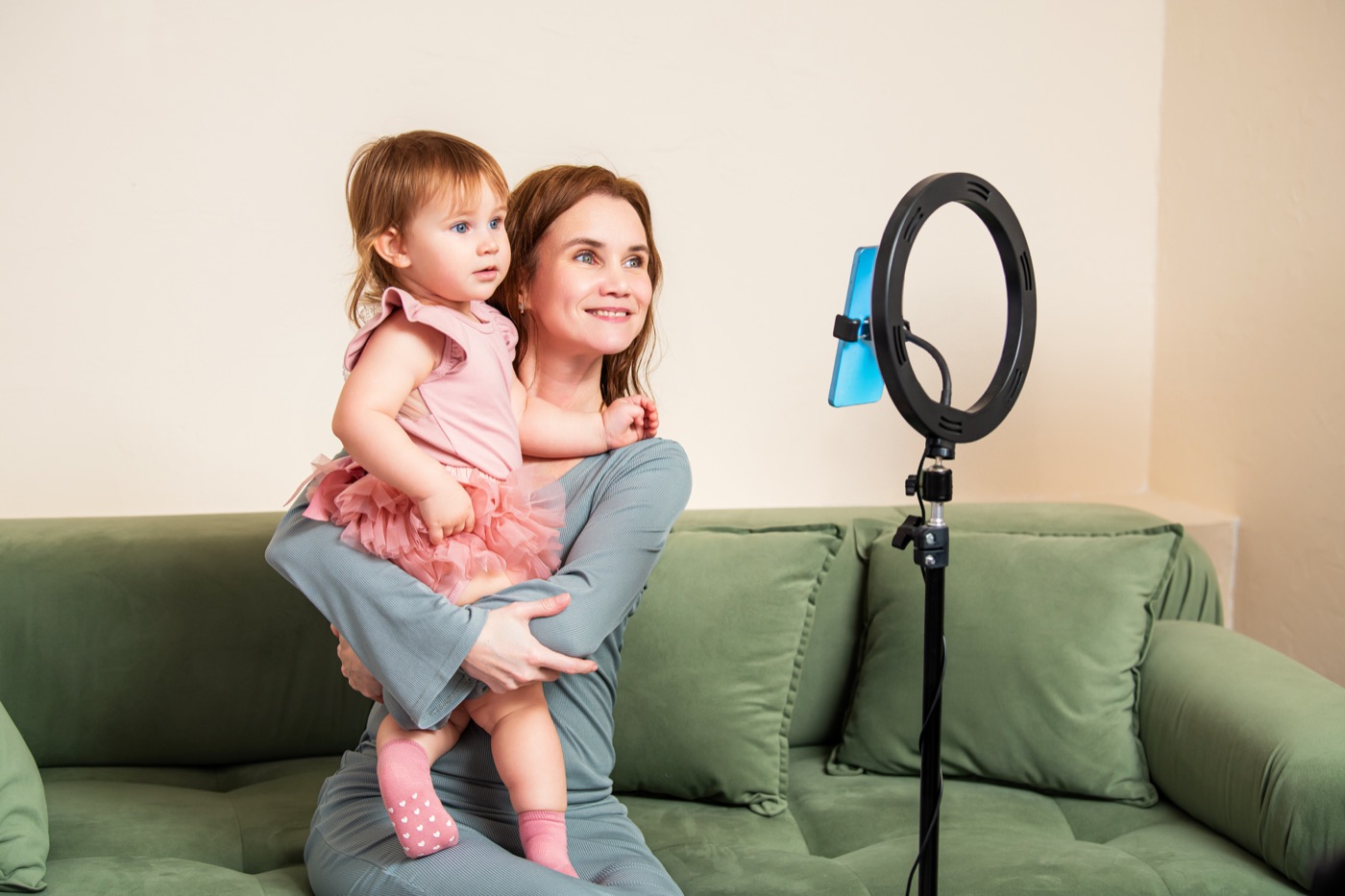 Mãe creator gravando um vídeo com o bebê e ring light para uma marca de maternidade.