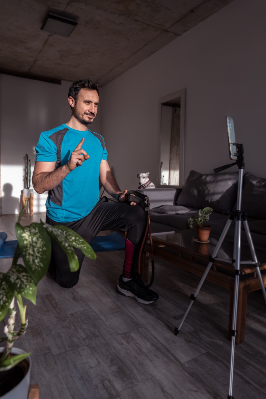 Creator gravando um vídeo de treino em casa com o celular para uma marca fitness.