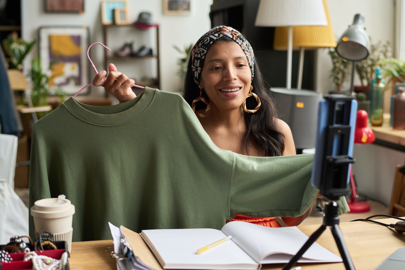 Creator de moda mostrando uma peça de roupa nova para o público em vídeo.