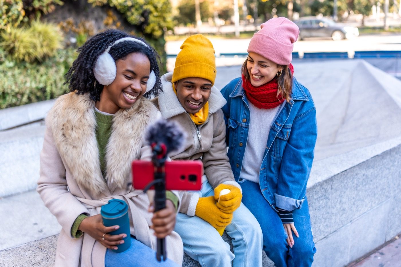Creators gravando conteúdo de viagem ao ar livre em uma cidade durante um passeio.